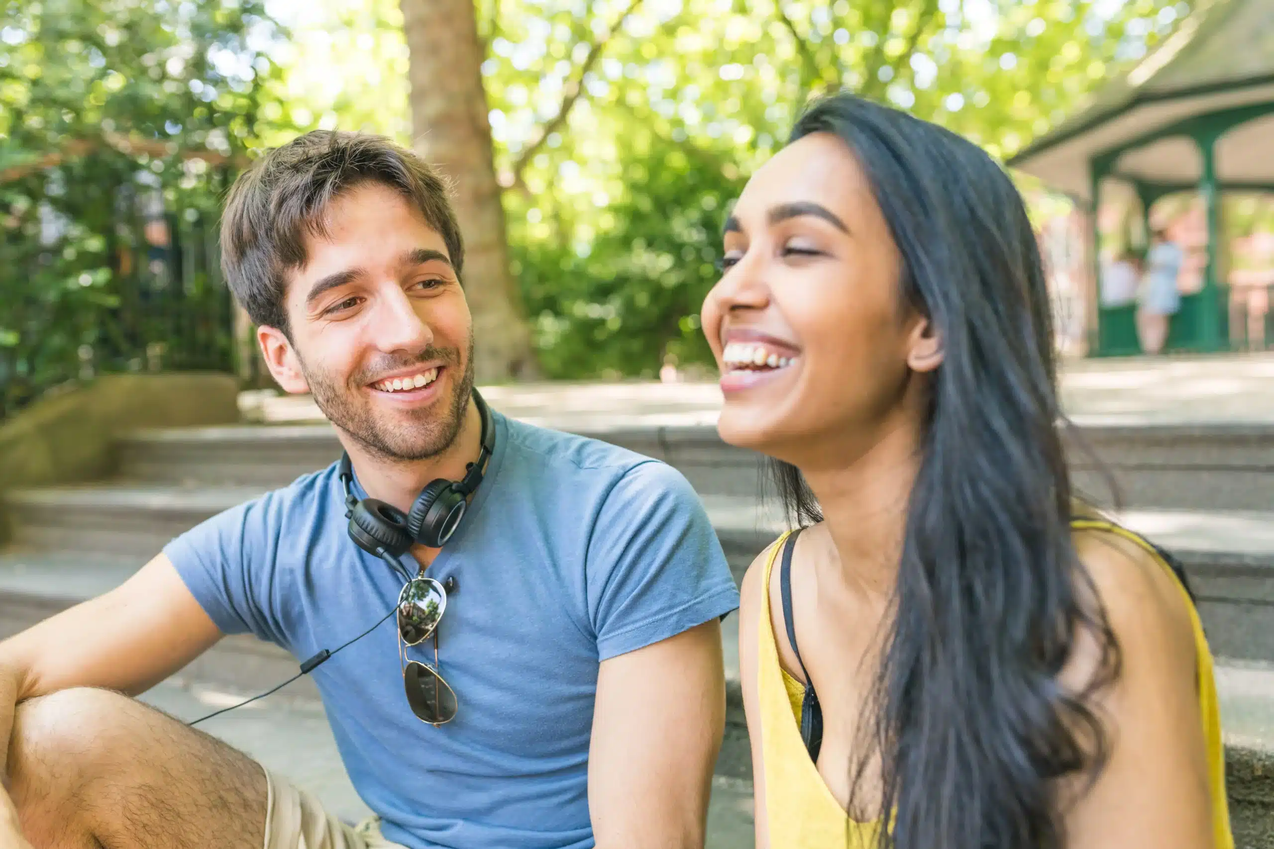 Young man and woman laughing together outdoors