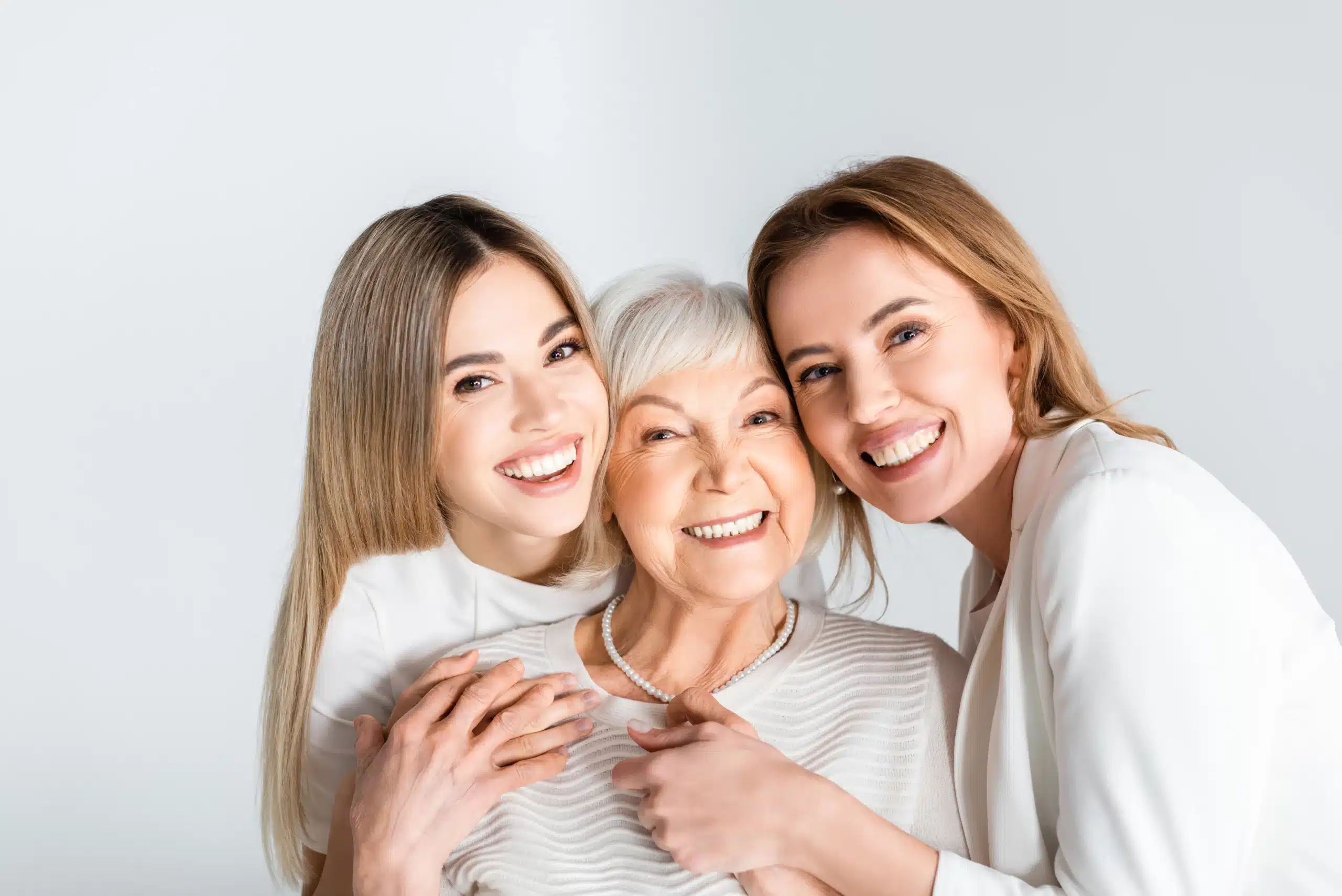 A multi-generational family of three women with radiant smiles, perfect for the Smile Gallery at Des Peres Dentistry