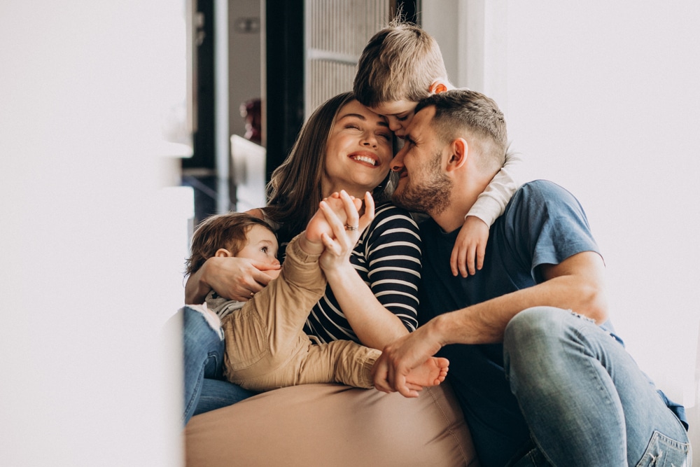 Parents laughing with their two young children at home